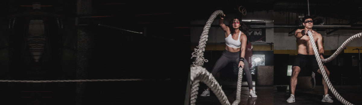 Man and woman performing rope exercise in a gym